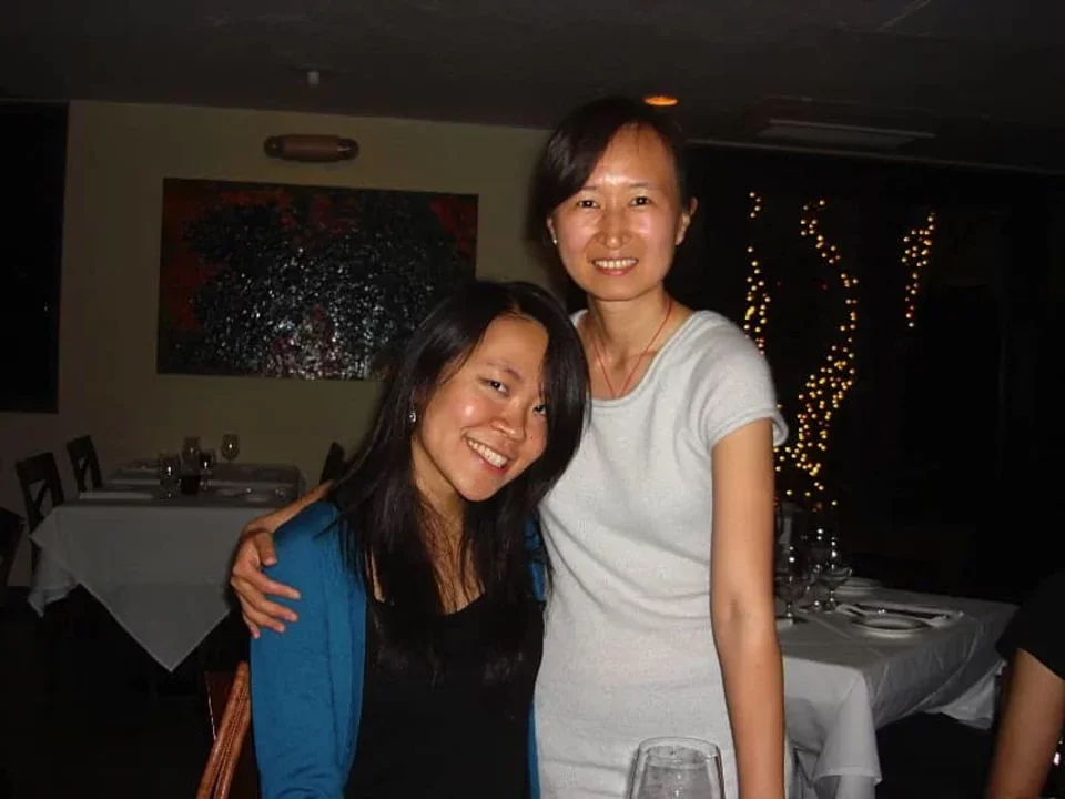 Two researchers stand smiling and angled at each other in a restaurant.