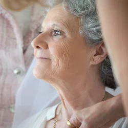 Two people care for an older woman.