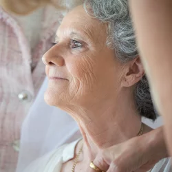 Two people care for an older woman.